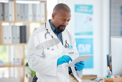 Image of Black man, doctor and tablet in medical research, planning or checking schedule appointment at hospital. Happy African male healthcare professional working or browsing touchscreen for clinic results