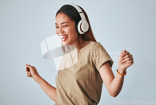 Image of Happy woman, music headphones and dancing in studio with excited and positive mindset. Female model on white background to dance, fun and laughing with energy while listening to audio or radio