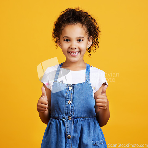 Image of Thumbs up, girl and happy portrait isolated with a orange background in studio and yes gesture. Youth, happiness and agreement kid hand sign with a smile showing positive, thank you and motivation