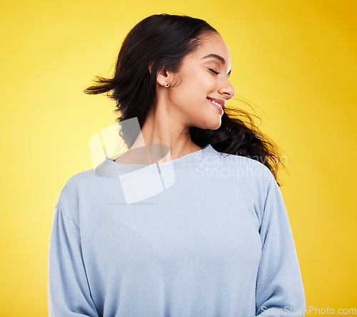 Image of Freedom, shake hair and woman in studio with beauty and smile, satisfaction and gen z, fashion on yellow background. Happiness, youth and Indian female is happy with haircare and cosmetics with shine