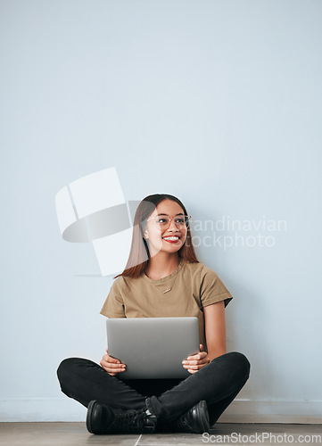 Image of Laptop, student woman and smile by a wall with computer work for learning with happiness. University, college and house with floor sitting of a happy young person ready for studying with mockup