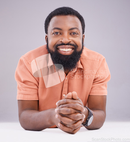 Image of Happy, corporate and portrait of a black man by a table isolated on a studio background. Smile, business and an African employee excited about work sitting by a desk, working and looking professional