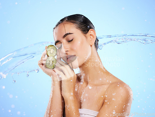 Image of Kiwi, beauty and water splash of woman, skincare and wellness on blue background mockup. Wet model, shower and healthy fruits for natural benefits, detox nutrition and dermatology with diet vitamins