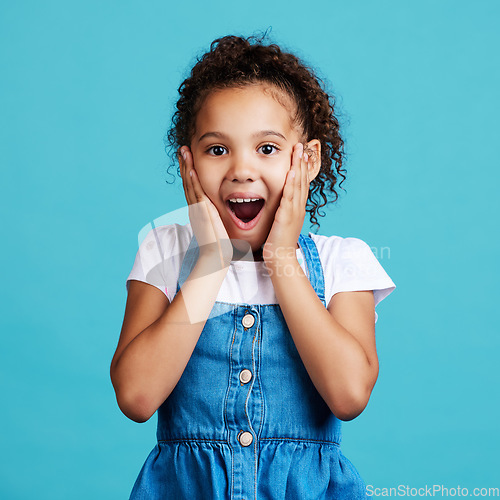 Image of Portrait, surprise and girl with smile, wow and cheerful against a blue studio background. Face, female child and young person with shock, facial expression and gasp with joy, happiness and emoji