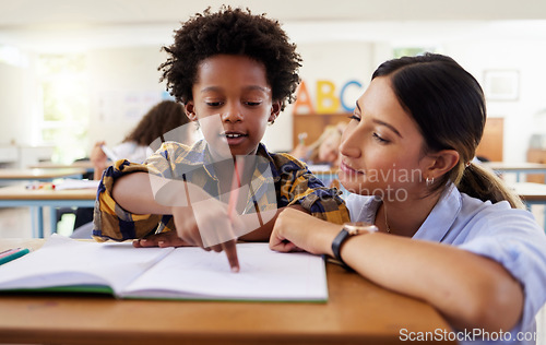 Image of Teacher, learning and helping black kid in classroom for knowledge, studying or assessment. Question, development and boy or student with woman for education pointing in notebook in kindergarten.