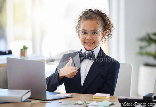 Image of Girl child, playing business and thumbs up with laptop for success, happiness and career games. Kid, happy smile and hand sign for deal, agreement and future by computer at desk in modern office