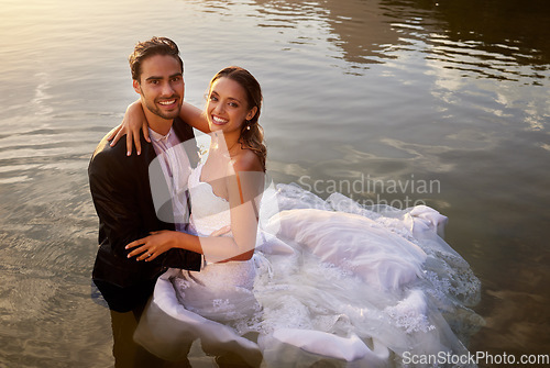 Image of Wedding, love and portrait of couple in the lake to celebrate their marriage in nature. Happy, smile and young wet bride and groom swimming in the pond water for romantic playful outdoor celebration.
