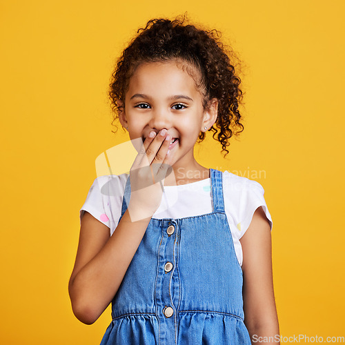 Image of Laughing, happy and portrait of a child in a studio with a comic funny joke and positive mindset. Happiness, smile and face of a girl kid model giggling for comedy while isolated by yellow background