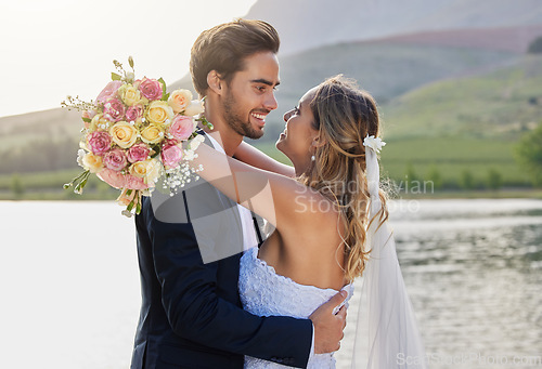 Image of Wedding, couple hug and lake with a bride feeling love, care and support from marriage together. Nature, flower bouquet and young people with a happy smile from trust and commitment event by water