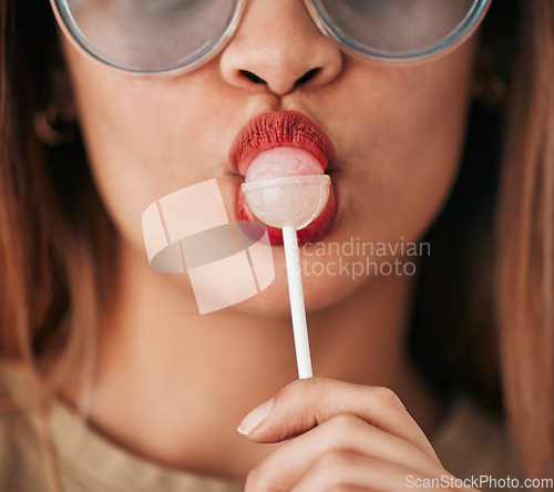 Image of Lollipop, woman and lips with lipstick, cosmetics and gen z style eating a sweet candy. Mouth, young person and food with makeup aesthetic and a hungry female model with sweets, dessert and product