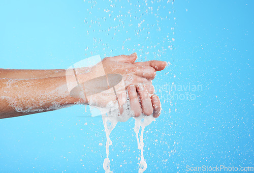 Image of Woman, handwashing and water drops with soap isolated on blue background with skincare and hygiene. Cleaning hands, hydration and wellness with mockup, shower and foam product, dermatology and health