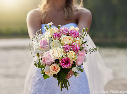 Image of Closeup, bride and flower bouquet outdoor for celebration of commitment, ceremony and marriage. Woman, wedding and holding roses, spring flowers and floral blossom to celebrate love at elegant event