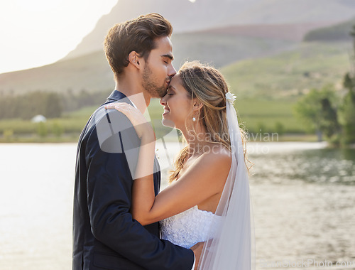 Image of Love, wedding with a bride and groom kissing by a lake outdoor in celebration of their marriage for romance. Water, summer and kiss with a newlywed couple bonding together in tradition after ceremony