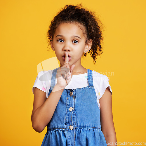 Image of Studio, portrait and child with finger on lips for secret or gossip isolated on yellow background. Face of young girl kid model with hand on mouth for silence, hush or quiet about mystery or surprise