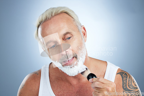 Image of Mature man, beard and shaving cream for skincare, grooming or hair removal against studio background. Senior male face applying shave creme or foam product with brush for haircare or facial treatment