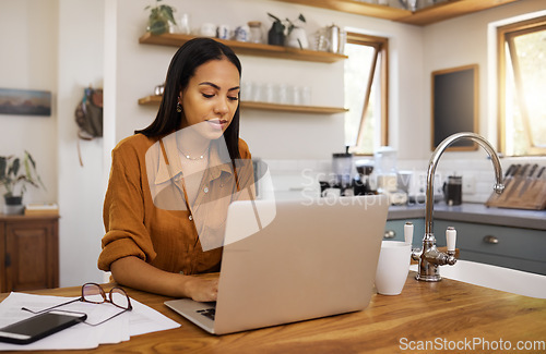 Image of Home, remote work and business woman on laptop for research project, strategy and planning in kitchen. Freelancer, focus and girl with documents working online, typing email and busy on computer