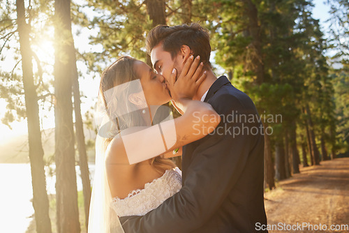 Image of Wedding, love and couple and kiss in park, forest and nature for celebration of union, care and marriage. Bride, groom and kissing in garden for romance, intimate bridal event or celebrate commitment