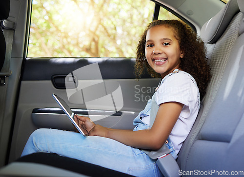 Image of Car ride, child portrait and tablet with a happy kid in a backseat with transportation travel. Video streaming, smile and happiness of a girl on road trip and adventure for holiday riding in vehicle