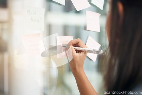 Image of Hands, brainstorming and woman writing notes for office schedule, agenda and mindmap goals at window. Closeup female employee planning ideas at glass for solution, information and strategy objectives