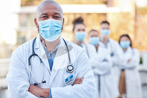 Image of Covid mask, doctor and black man in leadership outdoor with arms crossed for medical and health insurance. Face portrait of healthcare worker with ppe for safety, compliance and corona virus wellness