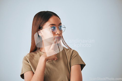 Image of Woman, thinking and space for idea with glasses in studio for advertising or product placement mockup. Female with hand on chin for doubt or planning logo or branding decision on a white background