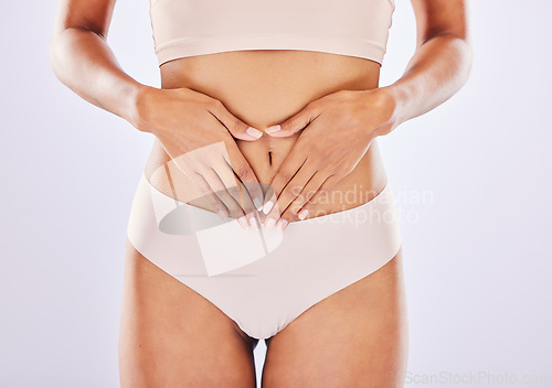 Image of Hands, stomach and belly of a woman natural model with smooth skin isolated in a studio white background. Weight loss, diet and female touch abdomen for healthcare, fitness and nutrition