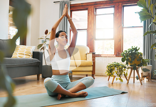 Image of Yoga, woman and hands above head for meditation, training and exercise at home living room, wellness and holistic health. Calm biracial person meditate, prayer or praying position in pilates workout