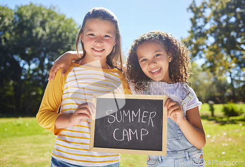 Image of Summer camp, portrait or happy girls in park together for fun bonding, development or playing in outdoors. Young best friends smiling, hugging or embracing on school holidays outside with board sign