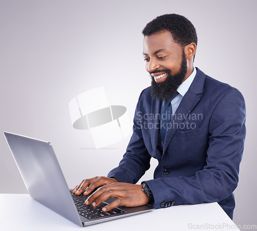 Image of Happy black man, business and laptop in studio for planning, corporate research and internet. Male employee, computer typing and background for website connection, online stocks and digital trader