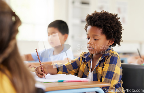 Image of .Education, writing and black boy in classroom learning, exam or studying with book. Preschool, development and serious kid and student write notes in notebook, reading and knowledge in kindergarten.