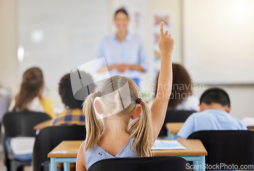 Image of Education, back and a child raising hand in class for a question, answer or vote at school. Teaching, academic and a student asking a teacher questions while learning, volunteering or voting