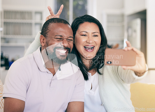 Image of Senior black couple, selfie or happy in home together for silly, social media or relax with peace sign hand. Mature man, woman and digital photography app in house for embrace, bonding and bunny ears