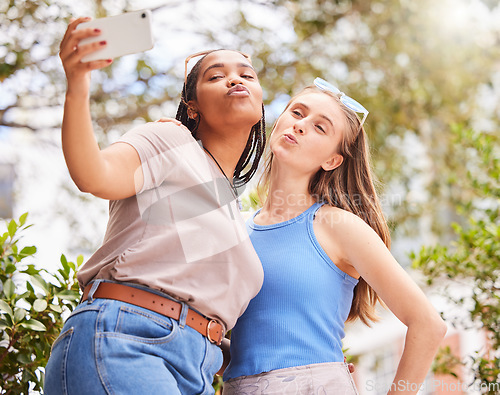 Image of Selfie, kiss and women friends bonding, chilling or hanging out outdoor in the park. Love, friendship and happy interracial females taking cute picture with a pout together in nature in green garden.