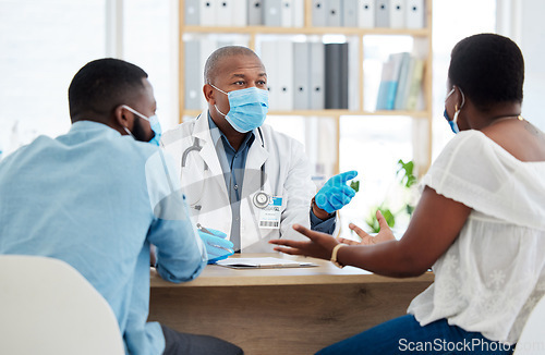 Image of Covid, health and doctor consulting a black couple in a hospital for wellness, insurance or treatment. Medical, healthcare or trust with a medicine professional talking to a man and woman in a clinic