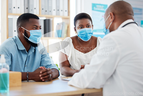 Image of Covid, healthcare and doctor consulting a married couple in a hospital for insurance or treatment. Medical, health or trust with a medicine professional talking to a man and woman in a clinic