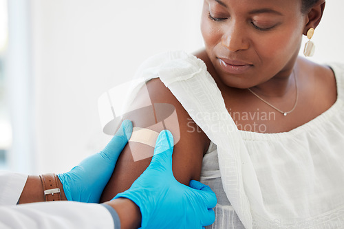 Image of Healthcare, plaster and doctor helping a patient after an injection or vaccine in the hospital. Consultation, appointment and hands of medical worker putting a bandaid on a woman in a medicare clinic