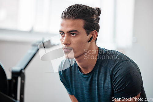 Image of Man, fitness and serious in gym, earpods and listen to music for motivation to exercise with training and wellness. Health, active lifestyle and young male with radio streaming, wifi and workout
