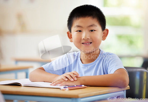 Image of Learning, portrait and Asian boy in classroom for education, exam or studying with book. Preschool, development growth and smile of happy kid and student from Japan in kindergarten for knowledge.