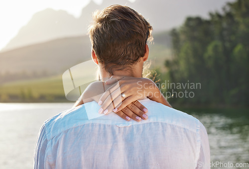 Image of Engagement, hug and couple by lake for romantic holiday, vacation and honeymoon in nature together. Love, proposal mockup and hands of woman holding man for embrace, hugging and affection outdoors