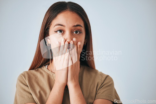 Image of Portrait, woman and surprise in a studio with a female cover mouth from shock. Isolated, grey background and hands on a face of a young person model with wow, worry and alert reaction from secret