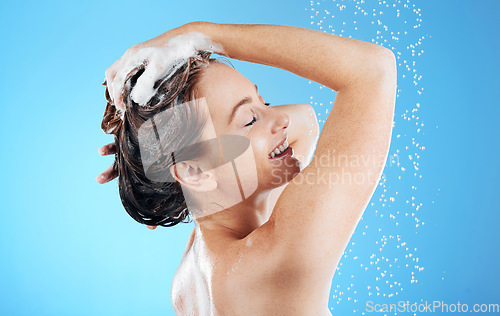 Image of Shampoo, washing hair and smile, woman in shower on blue background for morning bathroom routine in studio mockup. Healthy haircare, water and happiness for happy beauty model cleaning in soapy foam.