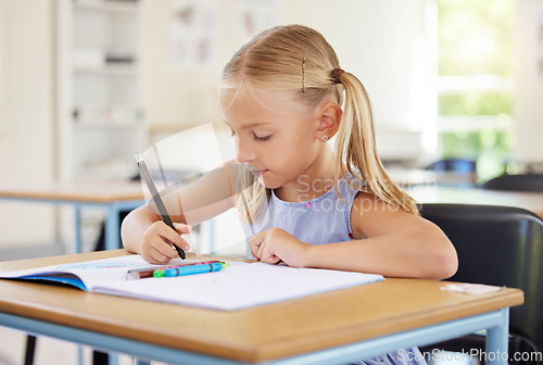 Image of Education, drawing and girl in classroom learning, exam or studying with book. Preschool, development and serious kid and student with creative art in notebook, writing and knowledge in kindergarten.