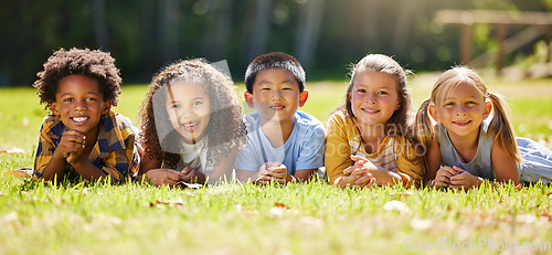 Image of Portrait, diversity and children on grass, friends and summer break with smile, chilling and relax. Face, kids and young group in park, multiracial and fun on vacation, weekend and joyful together