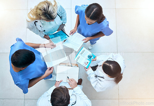 Image of Doctor, team and documents in collaboration above in healthcare planning, meeting or brainstorming at hospital. Group of medical professionals with paperwork in teamwork, strategy or ideas at clinic