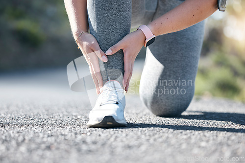 Image of Running, fitness and ankle injury with a woman on the street during a cardio or endurance workout. Medical, pain and accident with a female runner outdoor on a road for health, sports or training
