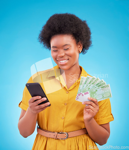 Image of Black woman, phone and money fan with smile, winning and finance goal in studio by blue background. Girl, smartphone and cash in hand from online casino, gambling or esports app on social media chat