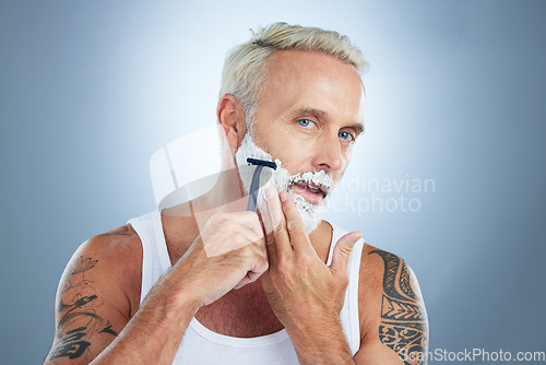 Image of Senior man, razor and shaving beard with cream for grooming, skincare or hair removal against a studio background. Portrait of mature male with shaver, creme or foam for hygiene or facial treatment