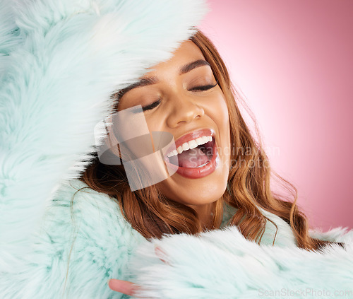 Image of Happy, stylish and woman in a fur coat isolated on a pink background in studio. Smile, classy and cheerful girl posing in a fashionable, trendy and fancy item of clothing, laughing and enjoying style