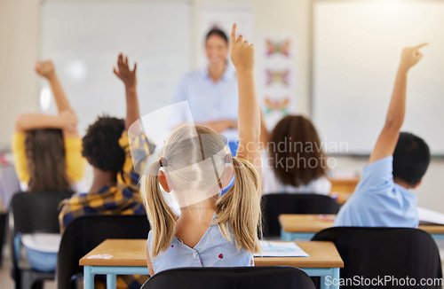 Image of Answering, back and children raising hand in class for a question, answer or vote at school. Teaching, academic and a student asking a teacher questions while learning, volunteering or voting