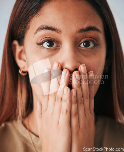 Image of Portrait, woman closeup and surprise in a studio with a female cover mouth from shock. Isolated, grey background and hands on a face of a young person model with wow, worry and alert reaction